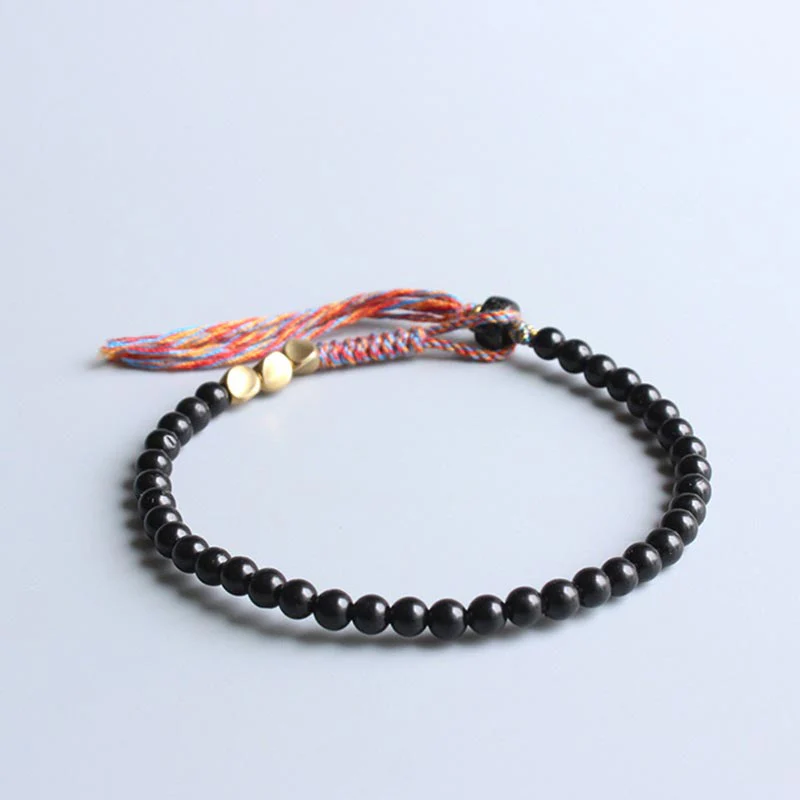 Braccialetto fatto a mano in onice nero tibetano con nappa Buddha Stones - Image 2